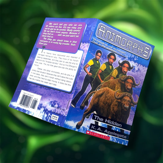 The front and back covers of a pocket notebook of Animorphs The Hidden on a blurred green background