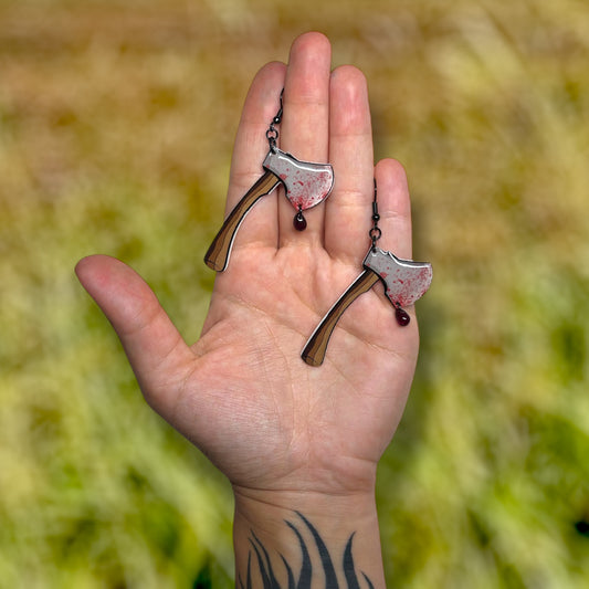 Bloody axe with glass blood drop resin statement earrings being held
