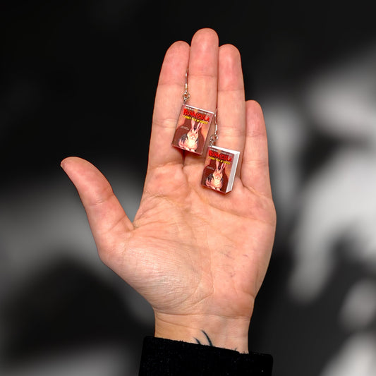 Bunnicula miniature book dangle earrings being held