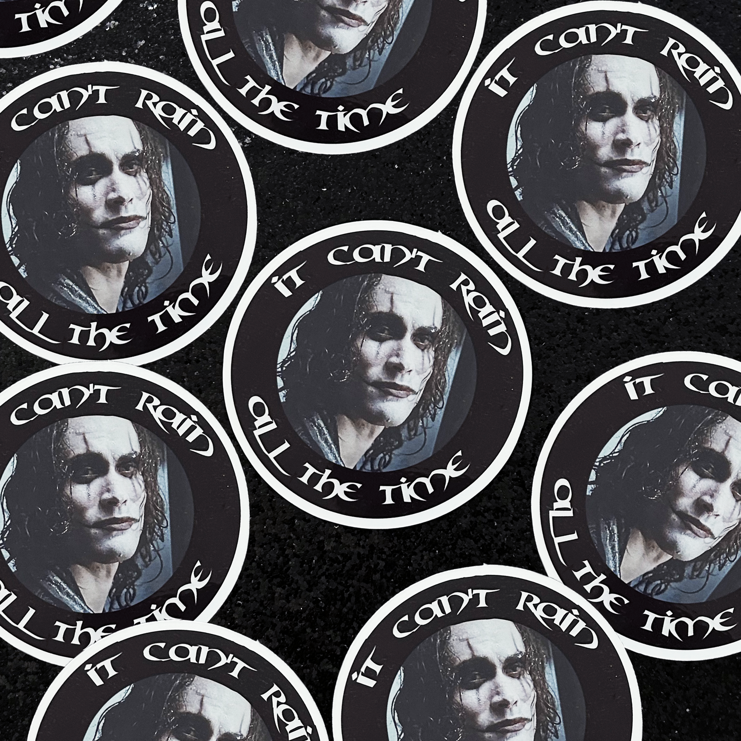 The Crow Eric Draven sticker and text 'It can't rain all the time' on a black background.