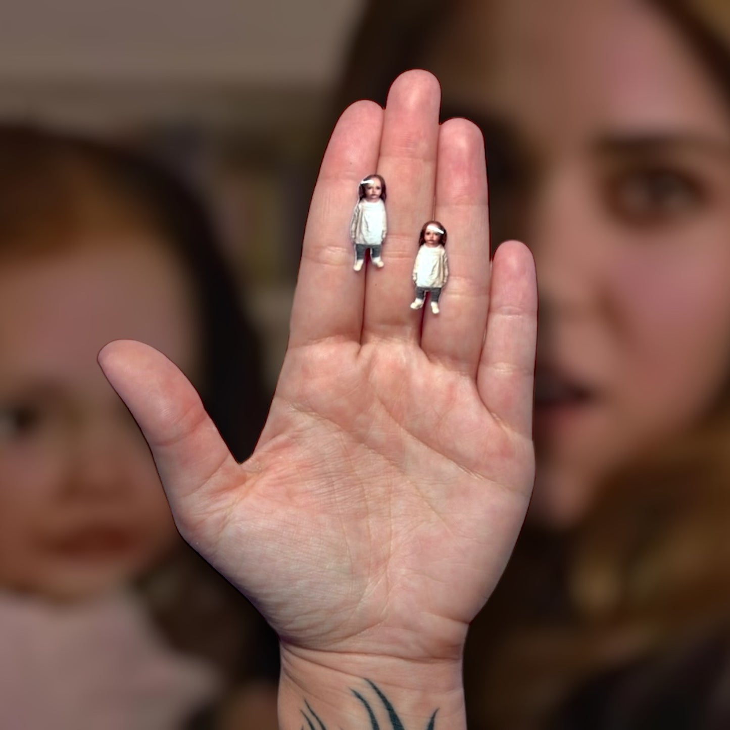 Twilight-inspired Breaking Dawn Renesmee baby resin stud earrings being held