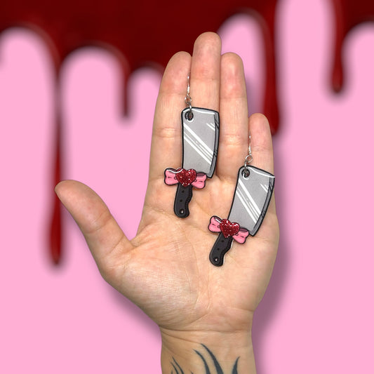 Cleaver sparkly pink heart bow Valentine's Day Valloween resin statement earrings being held