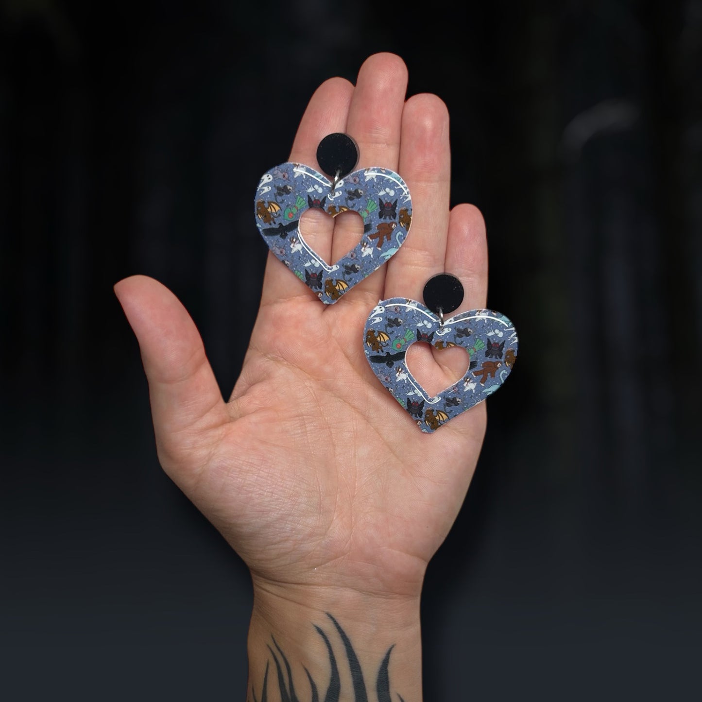 Cryptid Mothman Bigfoot Loch Ness Monster Fresno Nightcrawler Chupacabra Flatwoods Monster Jackalope mod hearts resin statement earrings being held