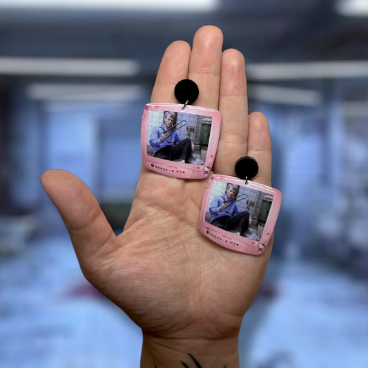 SAW Dr. Gordon sawing off foot Hello Kitty TV resin statement earrings being held