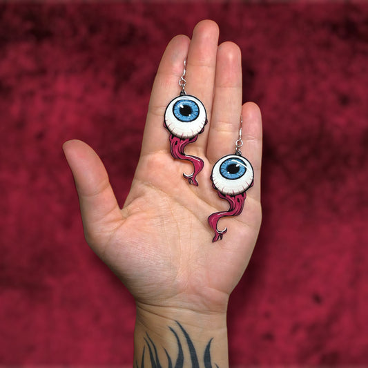 Blue eyeball oddities curiosities resin statement earrings being held