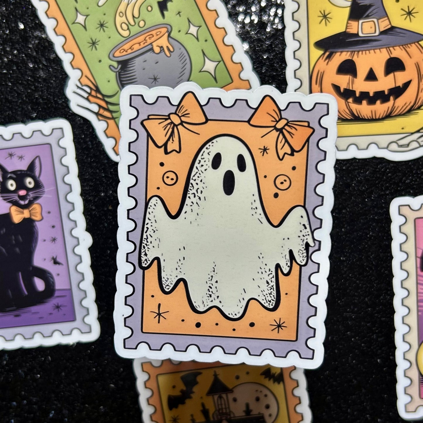 Sticker of a ghost on an orange background surrounded by similar Halloween-themed stamp stickers.