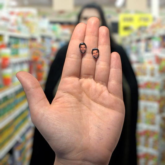 Kayvan Novak face resin stud earrings being held