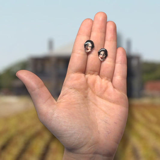Texas Chainsaw Massacre-inspired Leatherface resin stud earrings being held