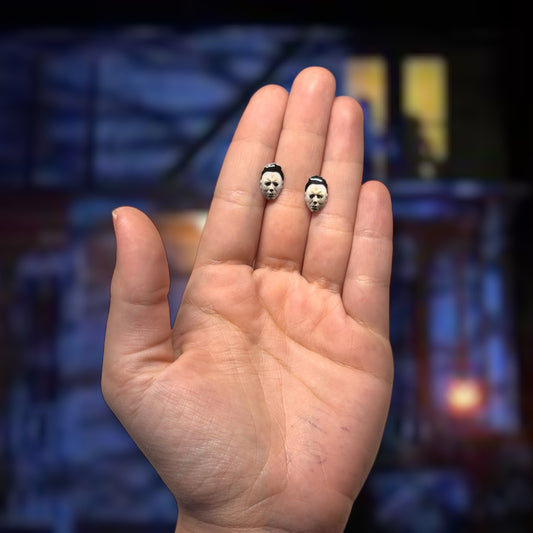 Halloween-inspired Michael Myers mask resin stud earrings being held