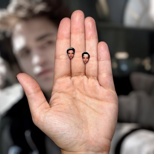 Robert Pattinson resin face stud earrings being held