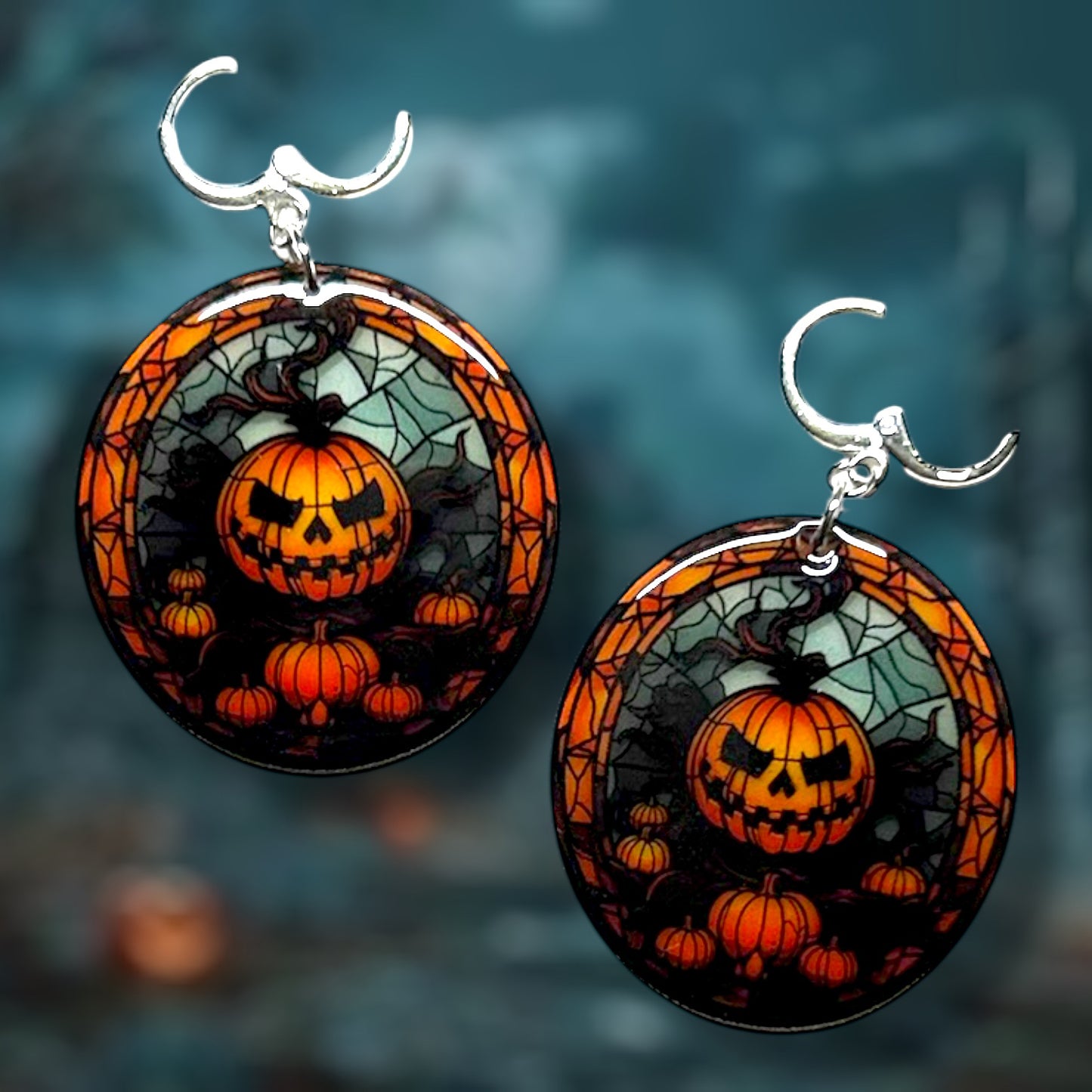 Halloween stained glass pumpkin jack o lantern earrings on a dark background