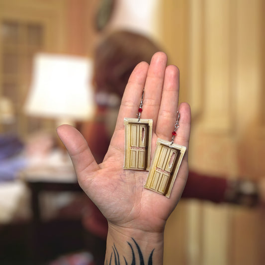 The Shining-inspired redrum door beaded resin statement earrings being held