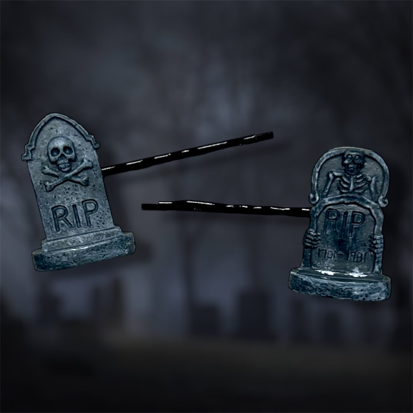 Two tombstone-shaped hair pins with 'RIP' on a dark background