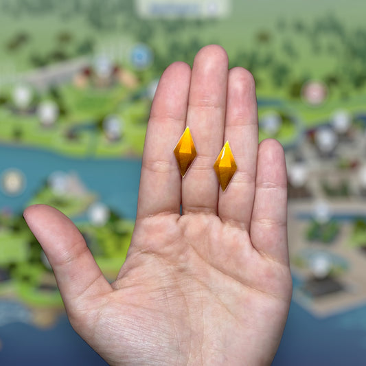 The Sims-inspired The Sims 4 TS4 yellow plumbob resin stud earrings being held