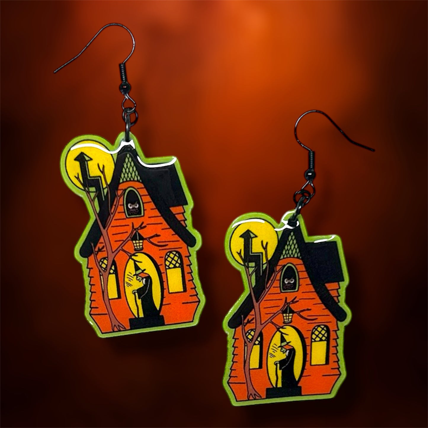 Halloween spooky haunted house with witch earrings on an orange background