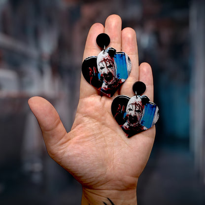 Terrifier Art the Clown bloody clown scary heart-shaped resin statement earrings being held