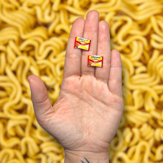 Beef flavored ramen noodles resin stud earrings being held