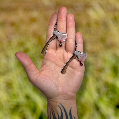 Bloody axe with glass blood drop resin statement earrings being held