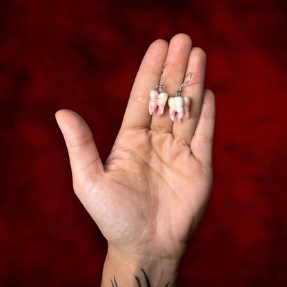 Bloody molar realistic human teeth oddities resin statement earrings being held