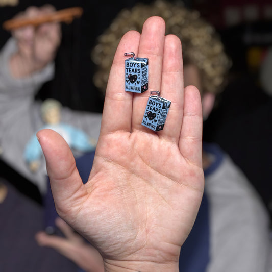 All Natural Boy's Tears resin stud earrings being held