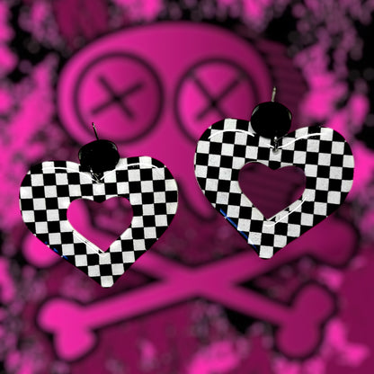 Black-and-white checkerboard elder emo mod heart resin statement earrings on a blurred pink background