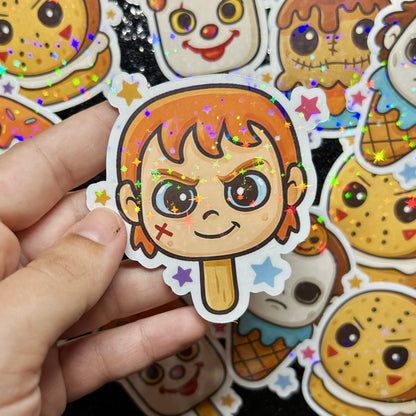 Hand holding a Child's Play Chucky popsicle with colorful stars against a background of similar stickers.