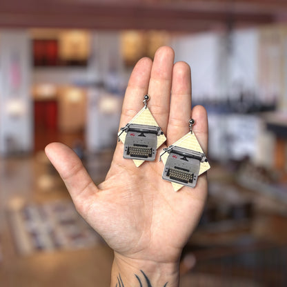 The Shining-inspired All Work and No Play Makes Jack a Dull Boy typewriter resin statement earrings being held