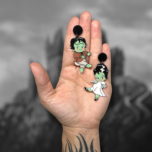 Frankenstein and The Bride of Frankenstein kewpie spooky cute Frankenstein's monster resin statement earrings being held