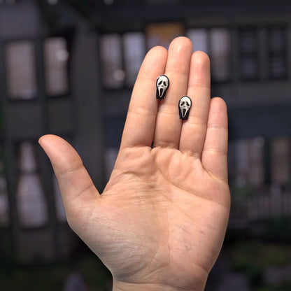Scream-inspired Ghostface mask resin stud earrings being held