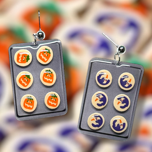 Pillsbury ghost cookie Pillsbury pumpkin cookie Halloween cookie sheet spooky cute resin stud earrings on a blurry orange and purple background