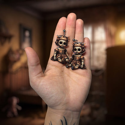 Creepy haunted doll resin statement earrings being held