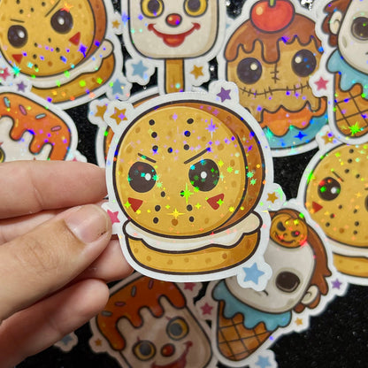 Hand holding a Friday the 13th Jason Voorhees cookie with colorful stars against a background of similar stickers.