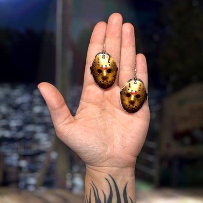 Friday the 13th-inspired Jason Voorhees hockey mask resin statement earrings being held
