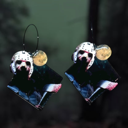 Friday the 13th Jason Voorhees hocket mask with bloody axe resin statement earrings on a blurry green and black background