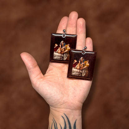 Judith Slaying Holofernes Artemisia Gentileschi framed art resin statement earrings being held