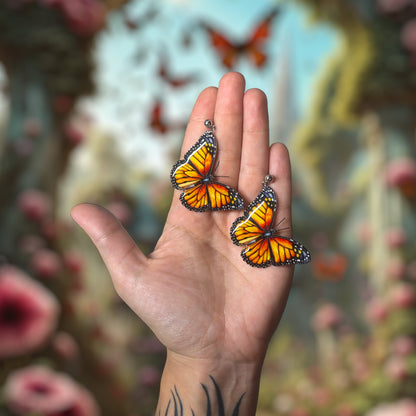 Monarch butterflies resin statement earrings being held