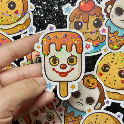 Hand holding an IT Pennywise popsicle with colorful stars against a background of similar stickers.