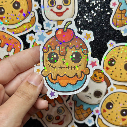 Hand holding a Trick-r-Treat Sam cupcake with colorful stars against a background of similar stickers.