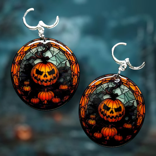 Halloween stained glass pumpkin jack o lantern earrings on a dark background