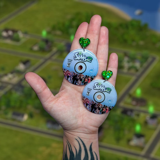 The Sims 2 game discs resin statement earrings being held