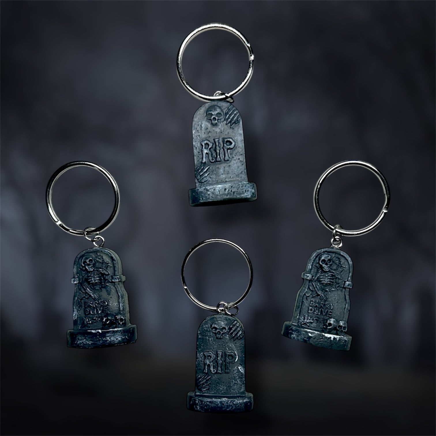 Four tombstone keychains with 'RIP' on a dark background