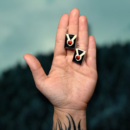 Twilight miniature book dangle earrings being held