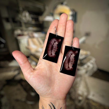 Vampire dental X-ray resin statement earrings being held