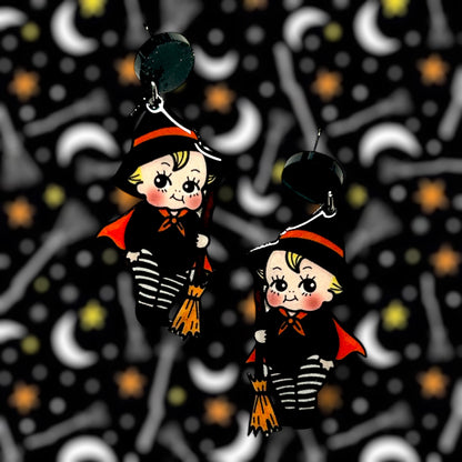 Halloween cute witch kewpie resin earrings on a blurry background