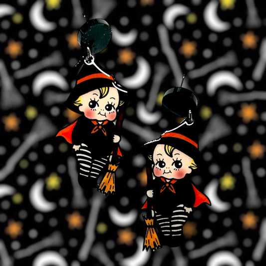 Halloween cute witch kewpie resin earrings on a blurry background