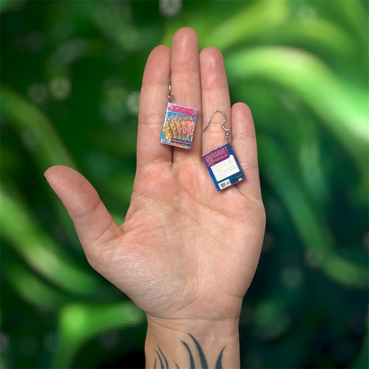 Hand holding a pair of Animorphs books on a blurry green background