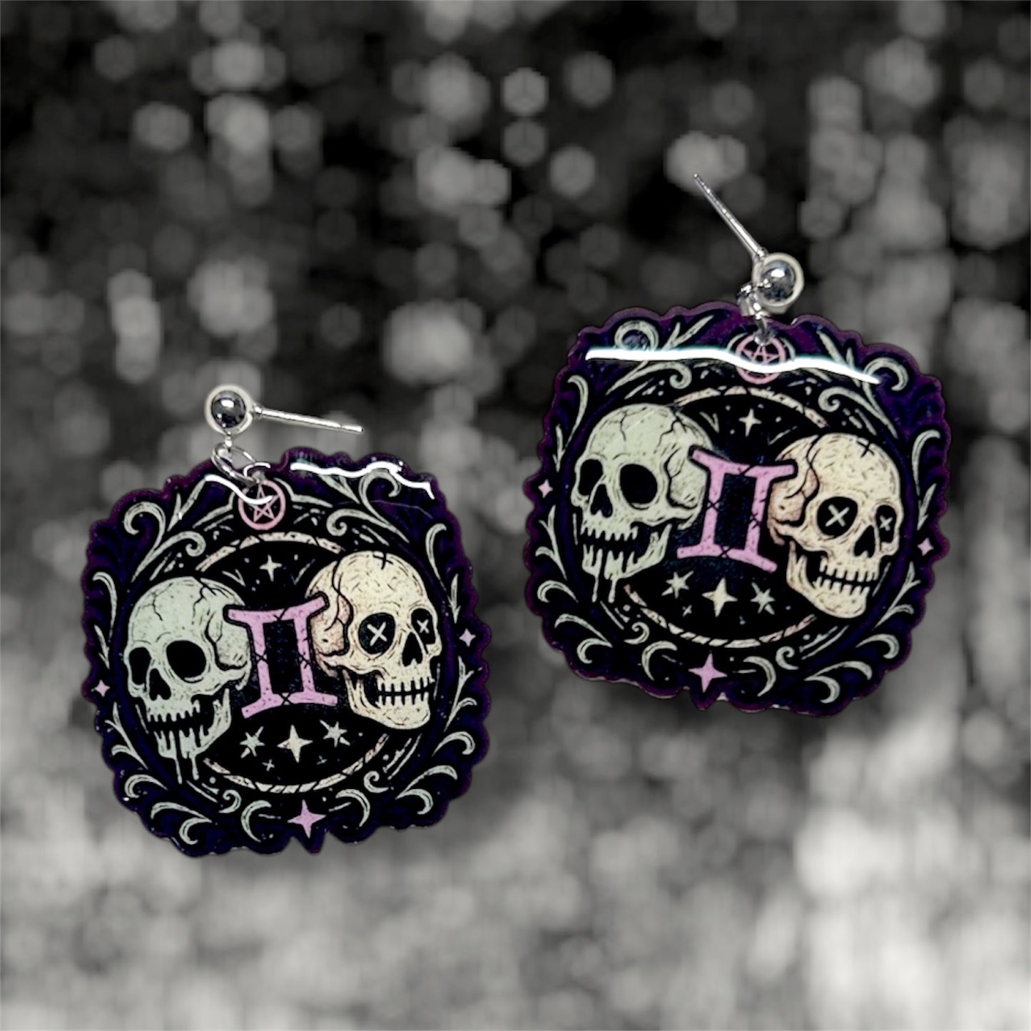 Gemini zodiac sign twin skulls witchy resin dangle earrings on a blurry black and white background