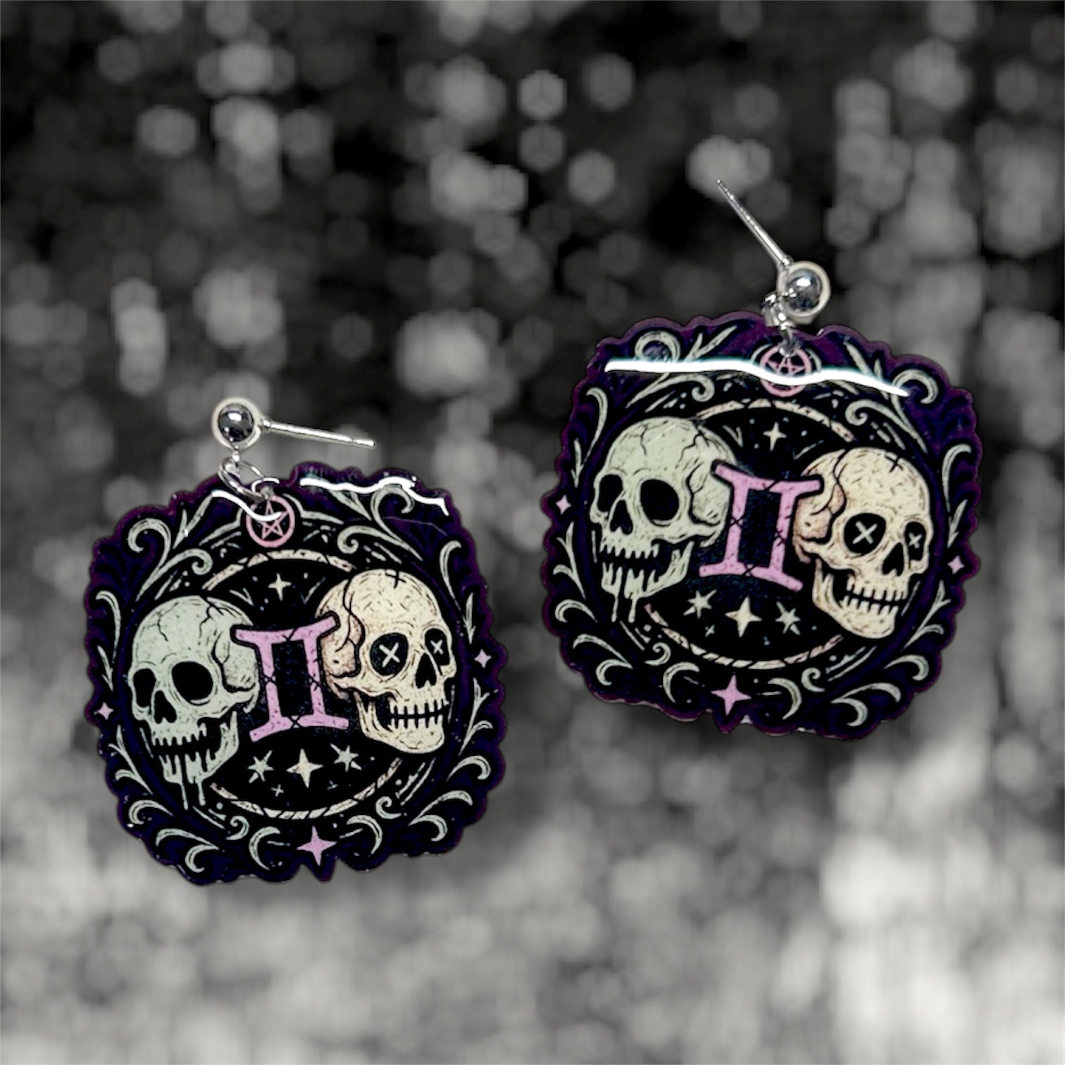 Gemini zodiac sign twin skulls witchy resin dangle earrings on a blurry black and white background
