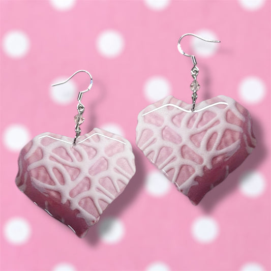 Little Debbie Valentine's Day heart snack cakes beaded resin dangle earrings on a blurred pink background