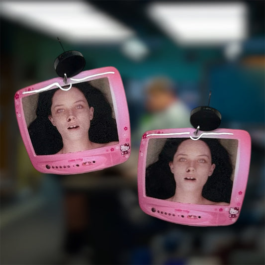 The Autopsy of Jane Doe Hello Kitty TV resin dangle earrings on a blurry background